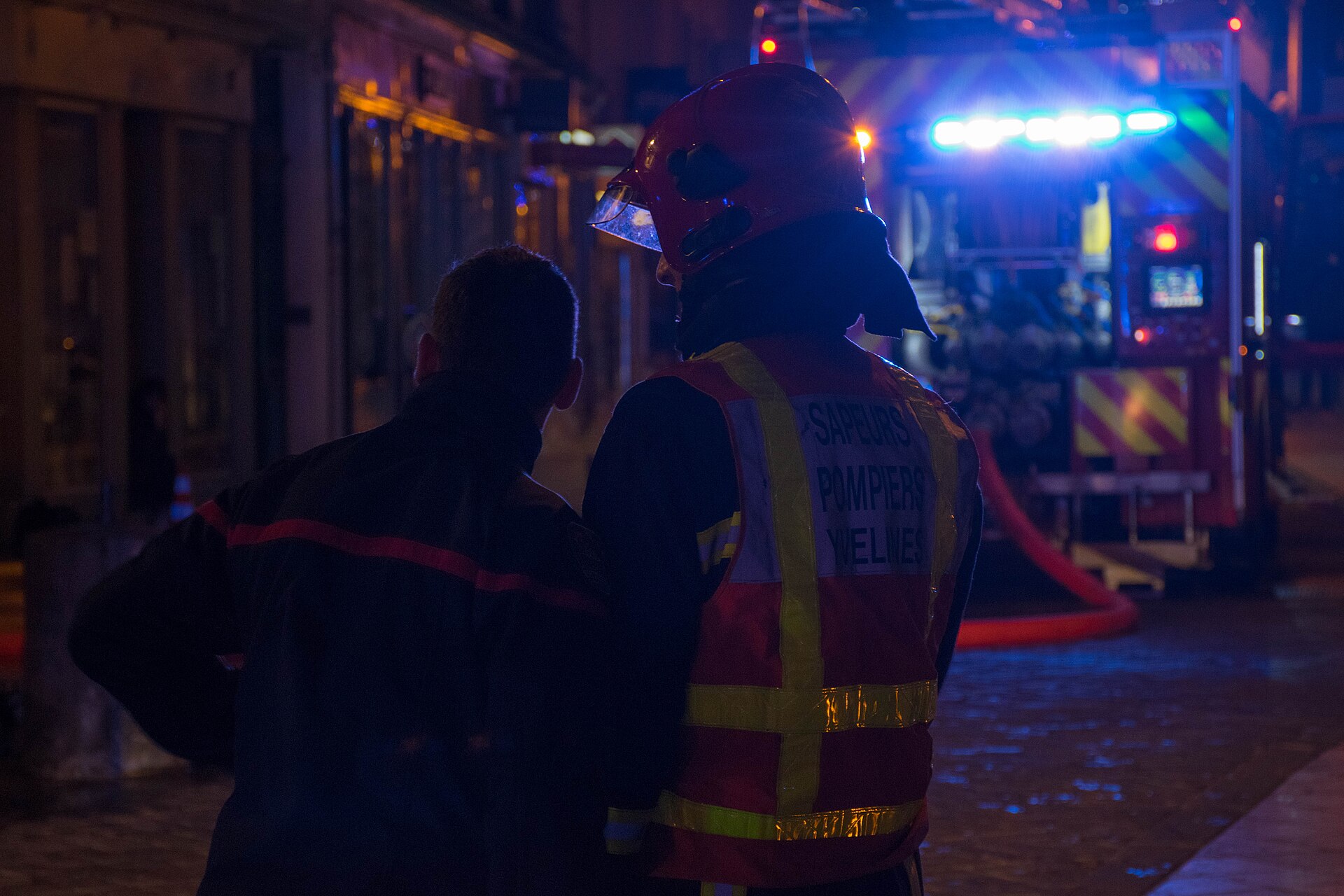Sapeurs-pompiers en intervention de nuit devant un fourgon